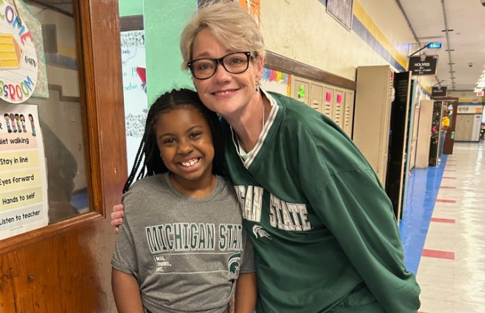  teacher standing with her student hugging 